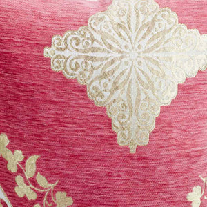 Florales Muster aus goldenen Blumen vor pink rosa Hintergrund. Eine Nahaufnahme des Fluffikon Dekokissen ist gezeigt.