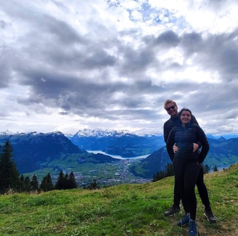 A couple standing in the Swiss mountains.