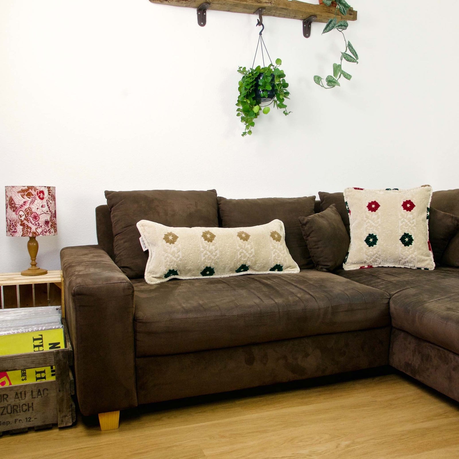 Lumbar and square velvet pillow on a brown couch.