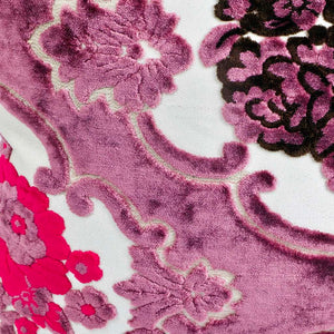 Nahaufnahme lila Fluffikon Samtkissen mit Blumenmuster. Das Kissen hat auch schwarze und pinke Blüten.