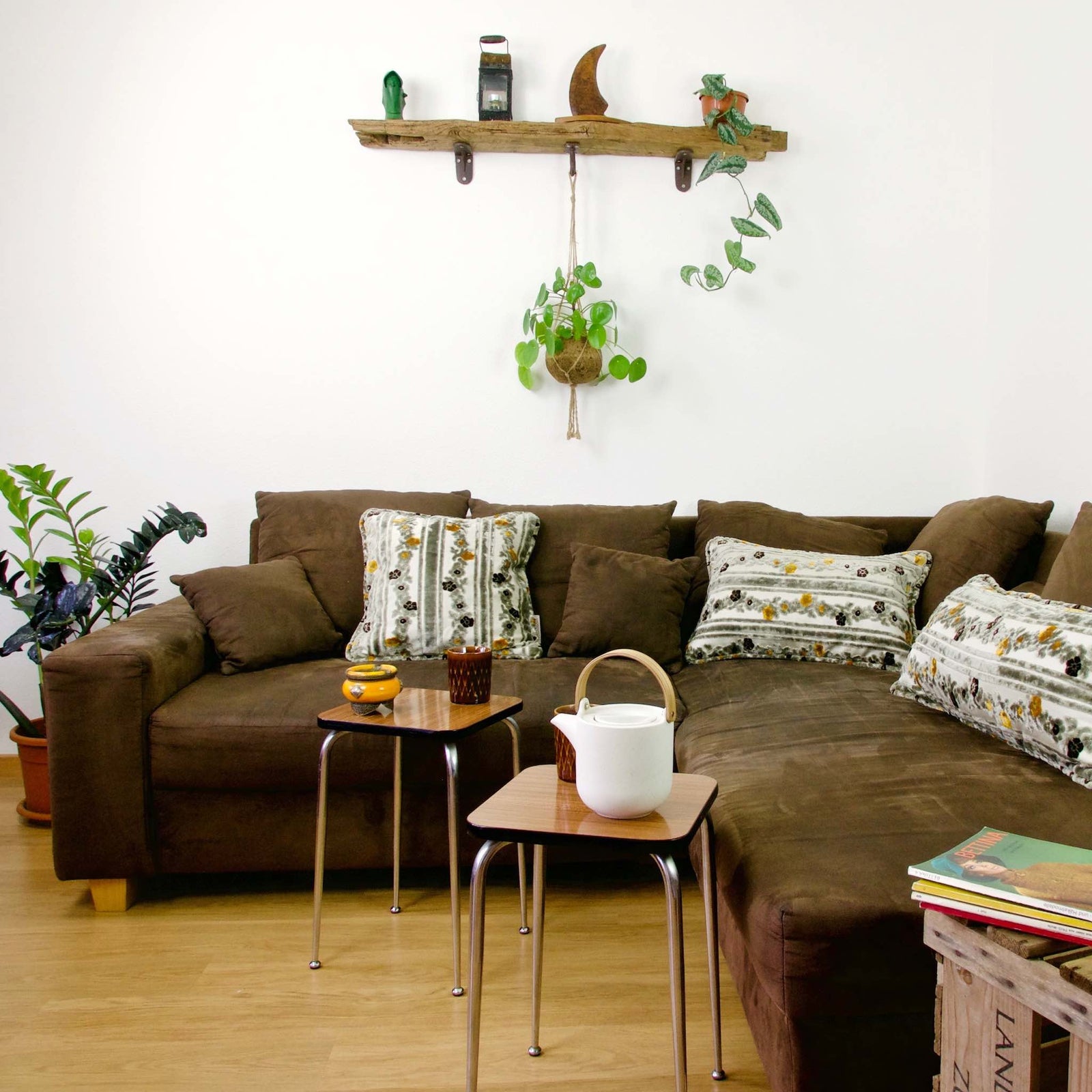 Three Cinnamon Love pillows on a brown couch in a living room.