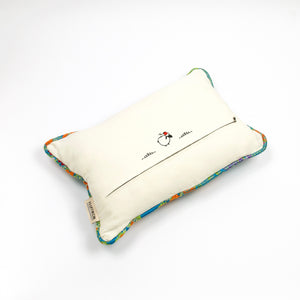 Blue Fluffikon decorative rectangular pillow made from shiny brocade with colourful flowers embroidery. The back of the pillow is shown. Pillow is on the ground.