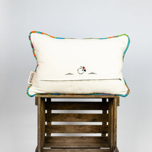 Blue decorative rectangular pillow made from shiny brocade with colourful flowers embroidery. Back of the pillow is shown. Pillow stands on a wooden box.