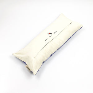 Blue-white decorative lumbar pillow made from silk with moroccan pattern. Back of the throw pillow made from cotton. Pillow on the ground.