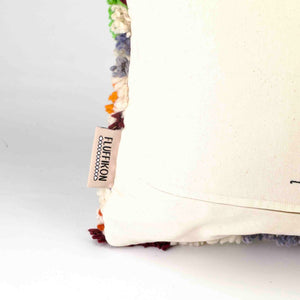 Nahaufnahme der Rückseite einer Ecke eines bunten Fluffikon Kinderzimmer Dekokissens.