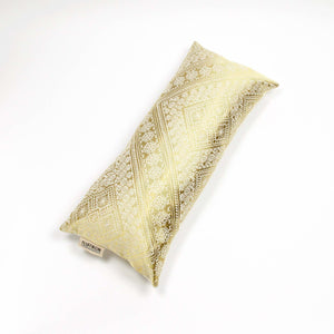 Fluffikon silk lumbar pillow made from golden moroccan fabric. The pillow is shown from the top.