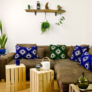 Blue and green Fluffikon velvet throw pillows on a couch.