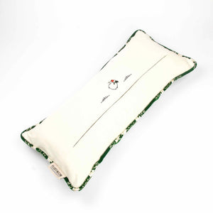 Grünes Sofakissen aus Samt vor weißem Hintergrund.