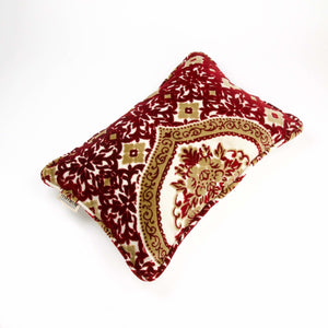 Samtkissen mit traditionellen marokkanischen Mustern vor weißem Hintergrund.