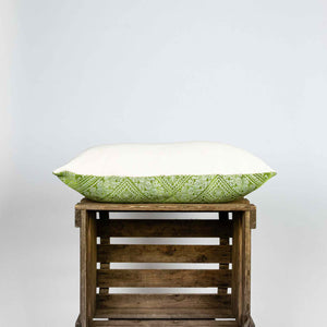 Fluffikon silk rectangular pillow made from green moroccan fabric. The pillow is shown from the side on a wooden box. Size 40x60 cm.