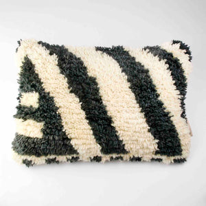 Rechteckiges (40x60 cm) Fluffikon Berber Kissen vor weissen Hintergrund. Das Kissen wurde aus einem Beni Ourain Teppich hergestellt.