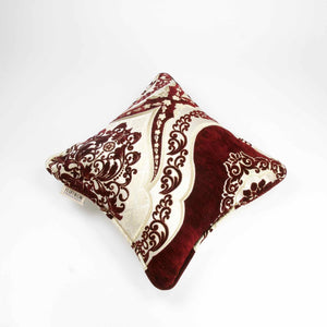 Rot weißes marokkanisches Zierkissen vor weißem Hintergrund.