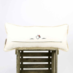 Large Moroccan pillow with piped edges on wooden box. The pillow is shown from the back.