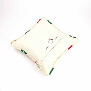 Square velvet pillow lying on a white background.