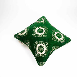 Green velvet throw pillow with white flowers. The pillows is dark emerald green.