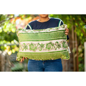 Fluffikon grey green decorative pillow with flowers made from moroccan velvet fabric. The throw pillow is shown from the front held by a woman.