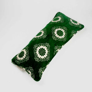 Green velvet lumbar pillow on white background.