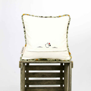 Moroccan throw pillow with piped edges on wooden box.