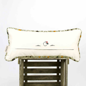 The back of an oversized sofa pillow on a wooden box.