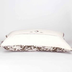 Large couch pillow with brown beige velvet. The pillow is shown from the back lying on the ground.