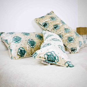 Three oversize Fluffikon pillows lying on a white bed. The pillows have an oriental look.