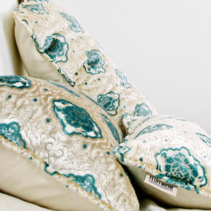 Oversize Fluffikon throw pillows. Three pillows are shown lying on the bed.