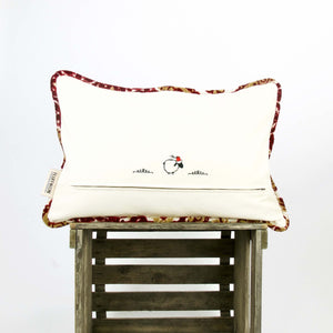 Velvet cushion with a little sheep stitched on the back of the pillow.