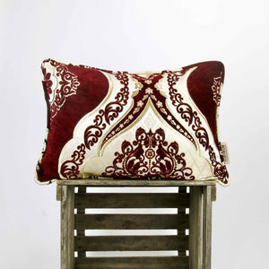 Burgundy red velvet decorative pillow on a wooden box.