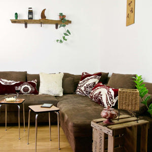 Red burgundy velvet pillow in a stylish bohemian home.