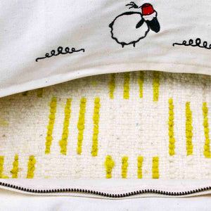 The inside wool fabric of a Beni Ourain Fluffikon lumbar pillow with yellow white checkered pattern