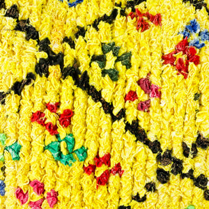 Zoom on yellow Boucherouite throw pillow. The yellow pillow has colorful dots.