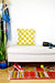 Yellow white checkered Beni Ourain pillow on a white bench in the living room.