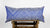 Blue and white Fluffikon silk pillow on a wooden box. The cushion is filled with swiss wool.