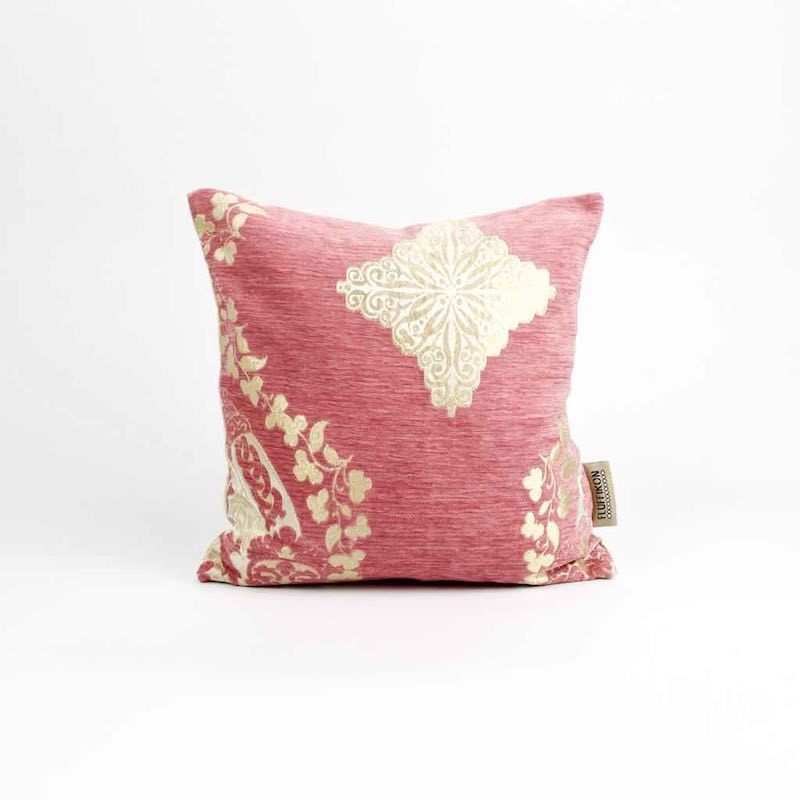 Blush pink Fluffikon throw pillow. The pillow has a traditional Moroccan pattern with golden flowers.
