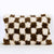 Brown white checkered Fluffikon throw pillow in front of white background. The Berber is made from a Moroccan Beni Ourain wool rug.