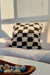 Checkered Fluffikon throw pillow in sunset light. The pillow is made from a Moroccan wool rug.