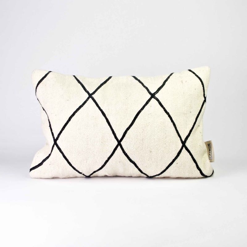 Fluffikon Kilim throw pillow with a size of 40x6cm. The pillows stands in front of a white background.