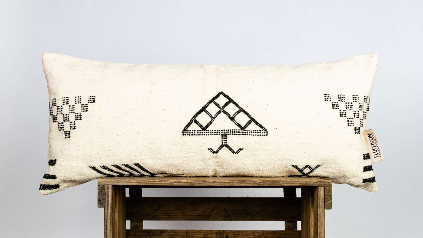 Fluffikon Kilim lumbar pillow on wooden box.
