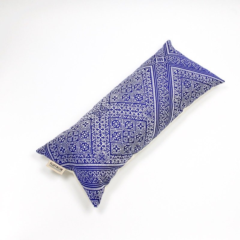 Blue silk cushion in front of white background.