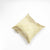 Gold silk cushion in front of white background.