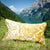 Grosses goldenes Kissen in den Schweizer Bergen. Das Kissen auf einer Wiese vor einem blauem See.