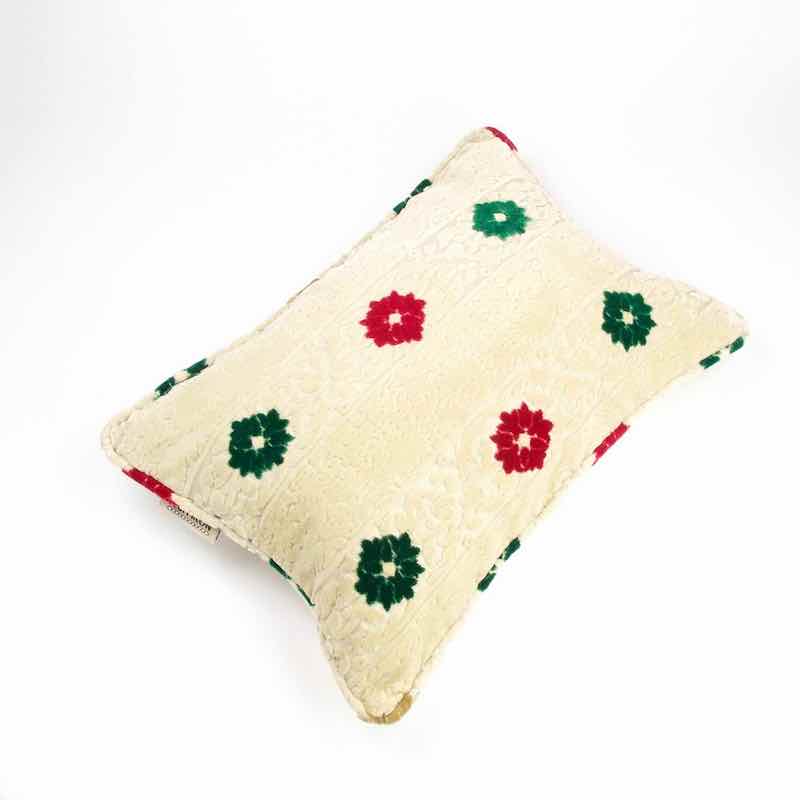 Marokkanisches beiges Sofakissen mit Blumen aus Samt vor weissem Hintergrund. 