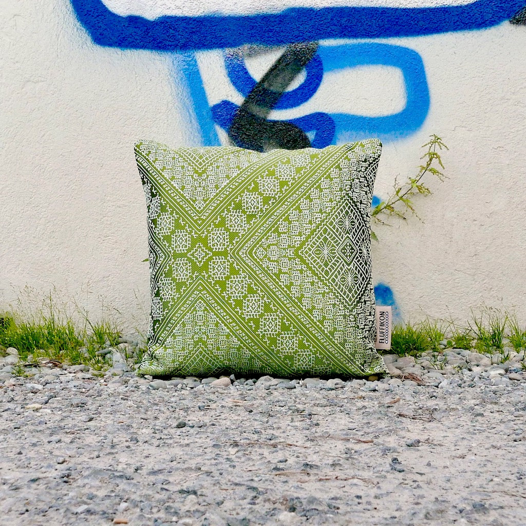 Green decorative silk pillow in front of Graffiti