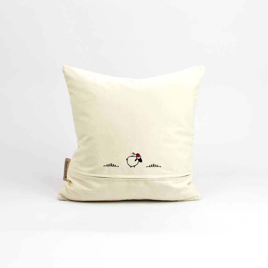 Die beige Rückseite eines pinken Fluffikon Dekokissen. Das Fluffikon Logo Lalla Soffa ist sichtbar.