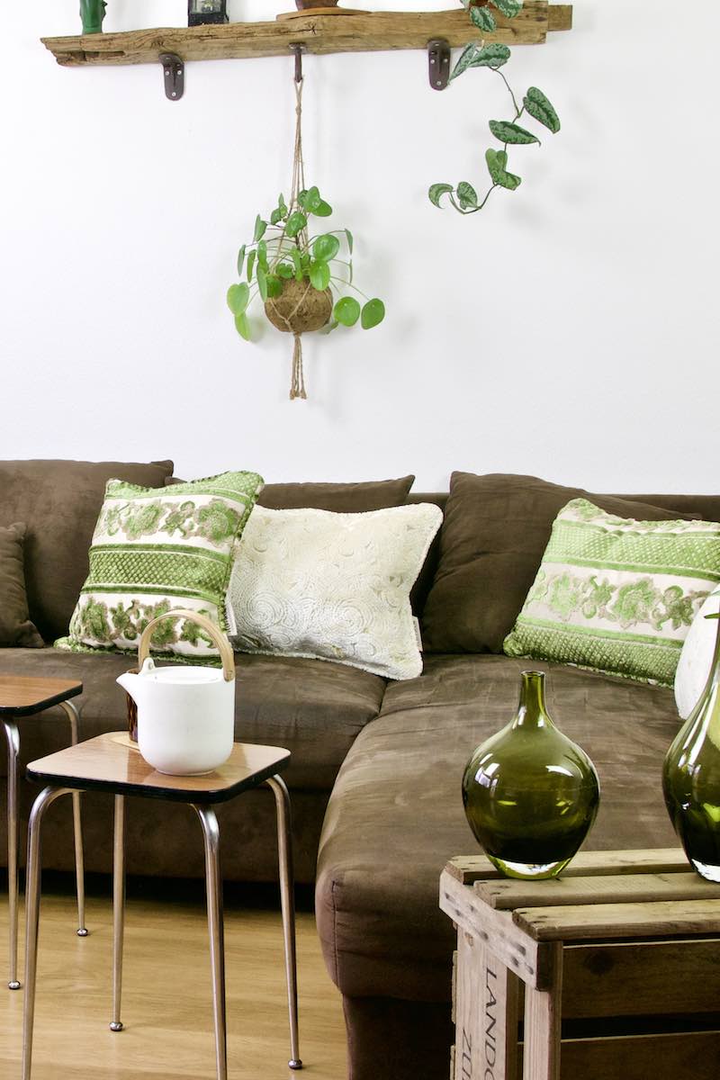Three velvet Fluffikon pillows in a living room. The pillows are placed on a brown couch.