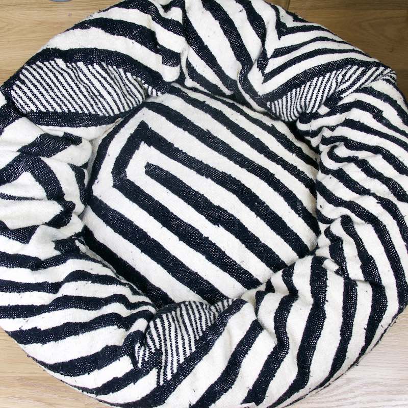 Top view on a black and white round Fluffikon Kilim cat bed. The bed has the pattern of a zebra.