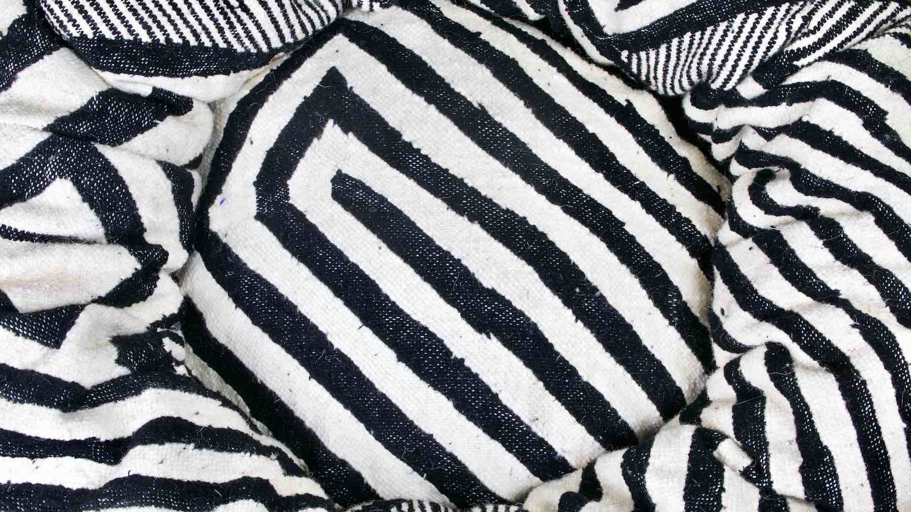 Zoom on a black and white Fluffikon Kilim cat bed. The Bed is made from a Moroccan Kelim rug.
