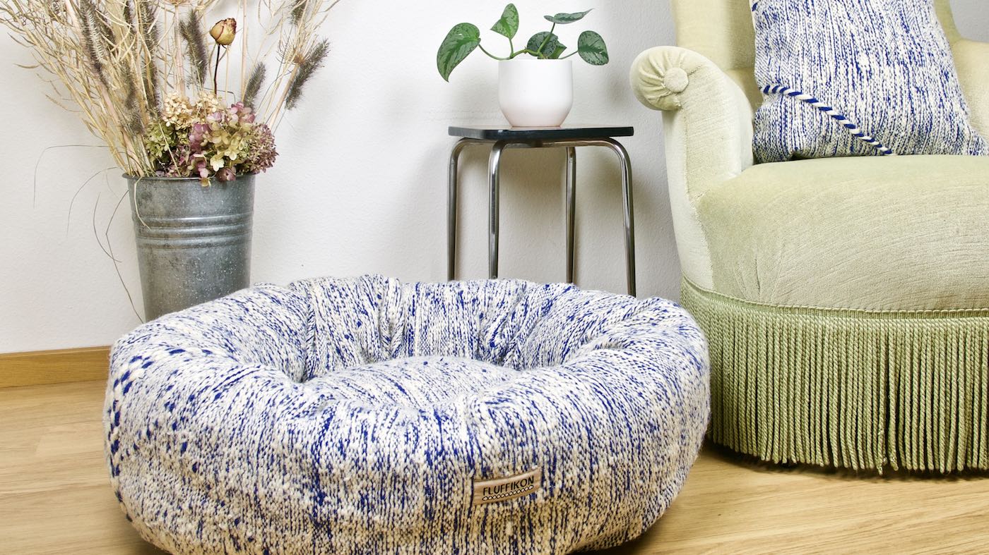 Blue and white Fluffikon Kilim dog bed that is made from a Moroccan rug. The pet bed is in a nice living room.