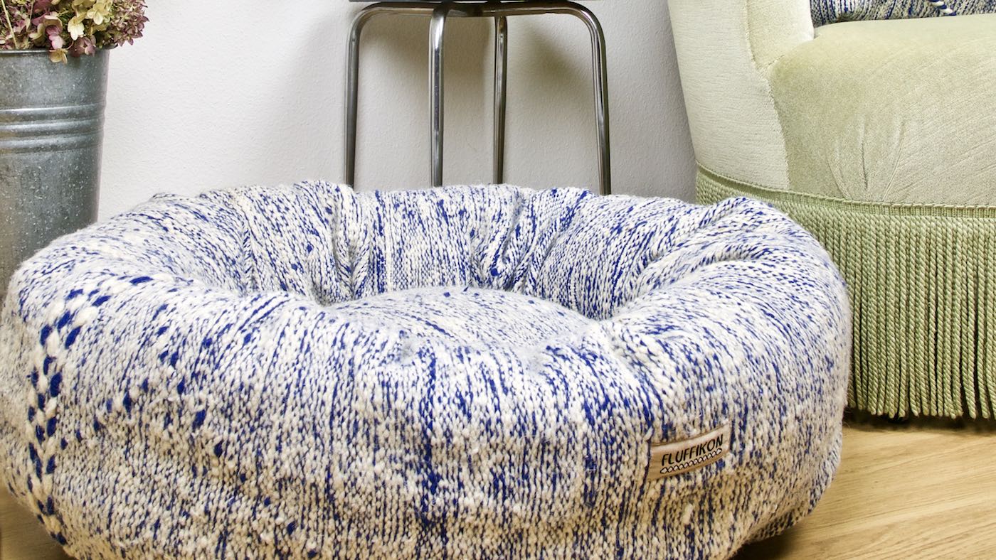 Close view on a blue and white Fluffikon Kilim dog bed that is made from a Moroccan rug. The pet bed is in a nice living room.