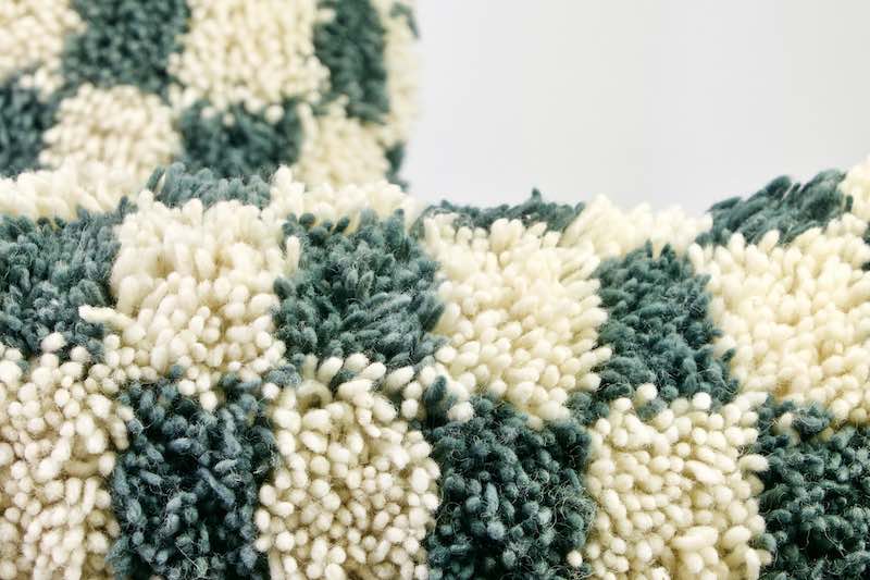 Grey-blue and white checkered Moroccan wool pillow. 